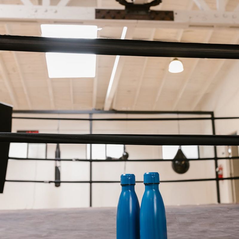 Detail of sports equipment and water bottle in a gym.